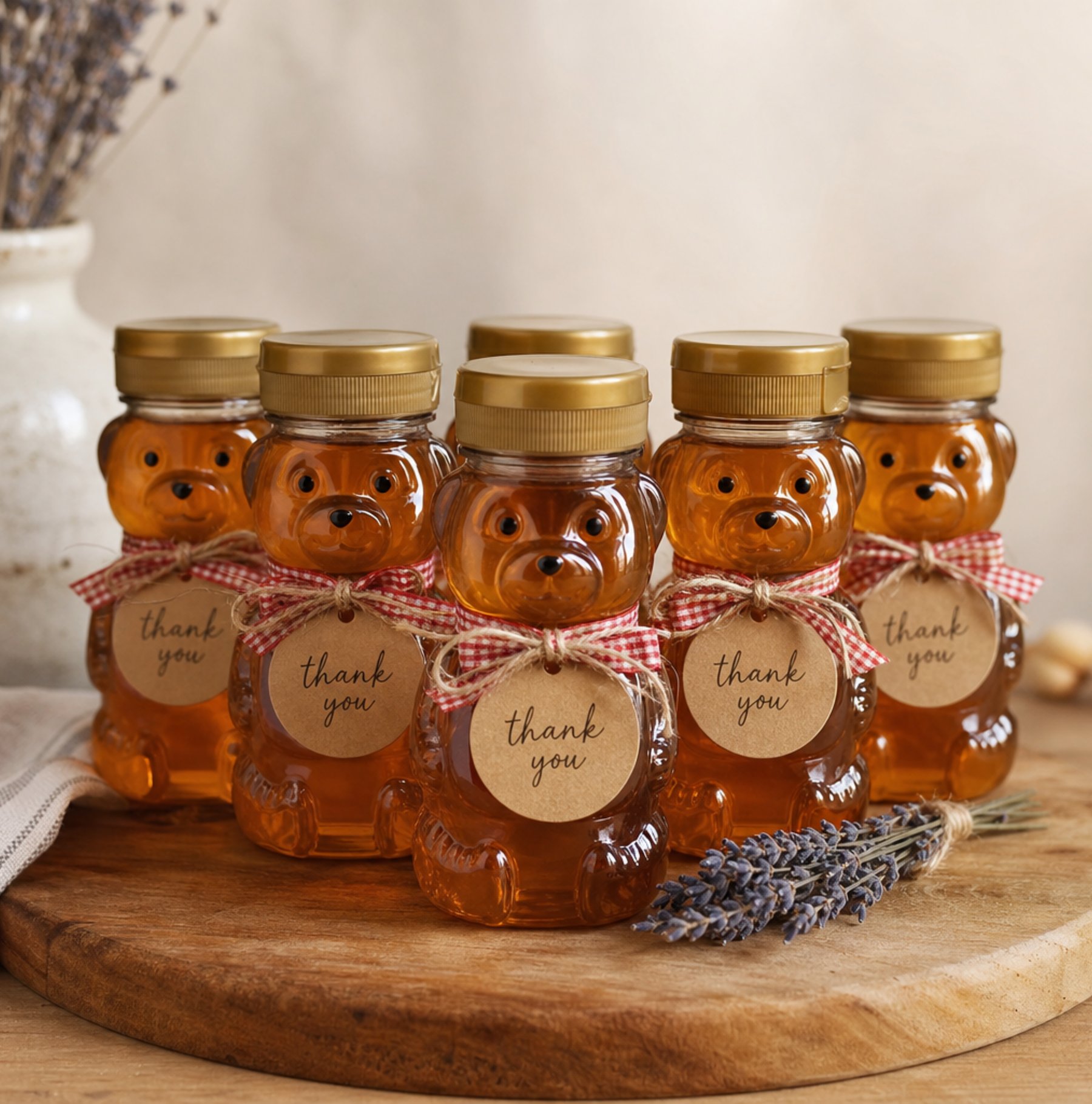 Small honey bear bottles with kraft labels and gold twine on wood board for locally grown baby shower favors
