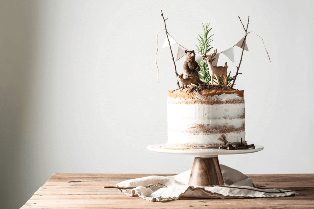woodland baby shower cake with forest animals and greenery cake toppers