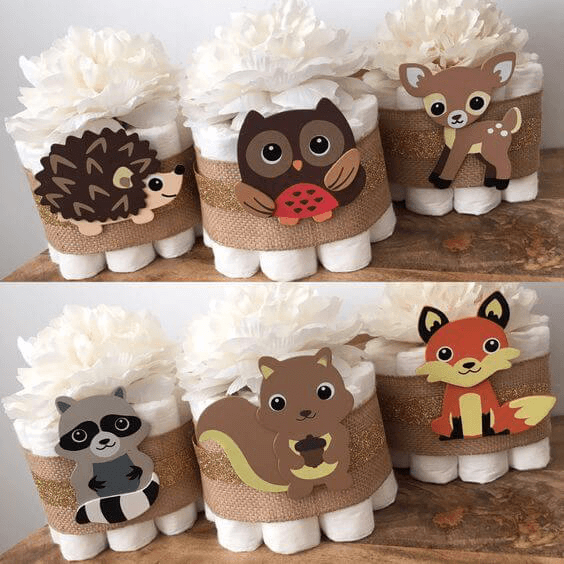woodland baby shower diaper centerpiece idea - roll diapers and add woodland embellishments
